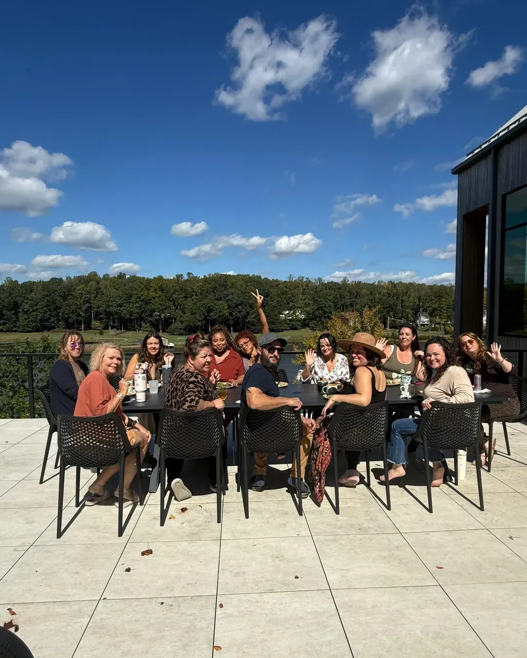The Root & Bloom Salon Source team gathered around a long table on the lakeside terrace at the annual Account Manager Retreat