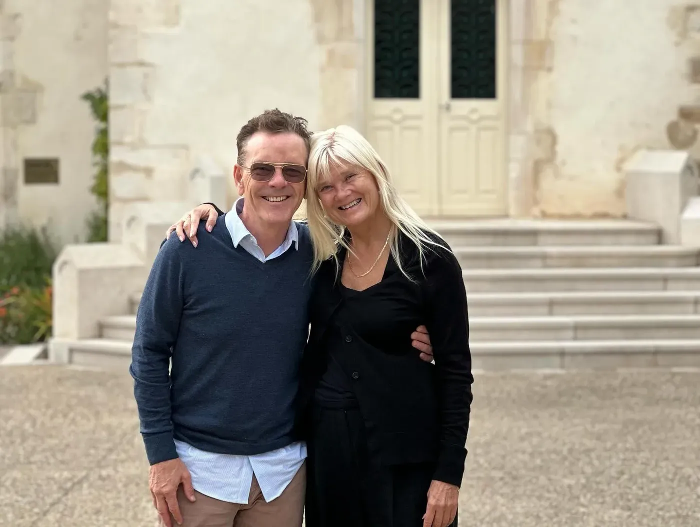 NATULIQUE founders Mette and Stig smiling outside a stone building