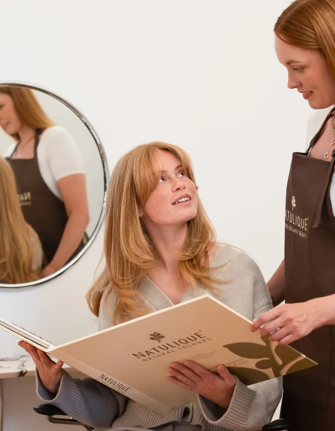 A Root & Bloom educator walking a stylist through the organic colour book